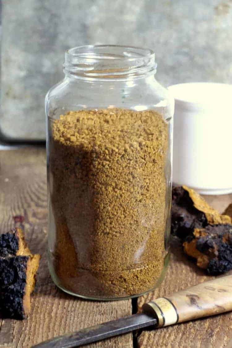 a glass jar filled with coarsely ground chaga mushroom