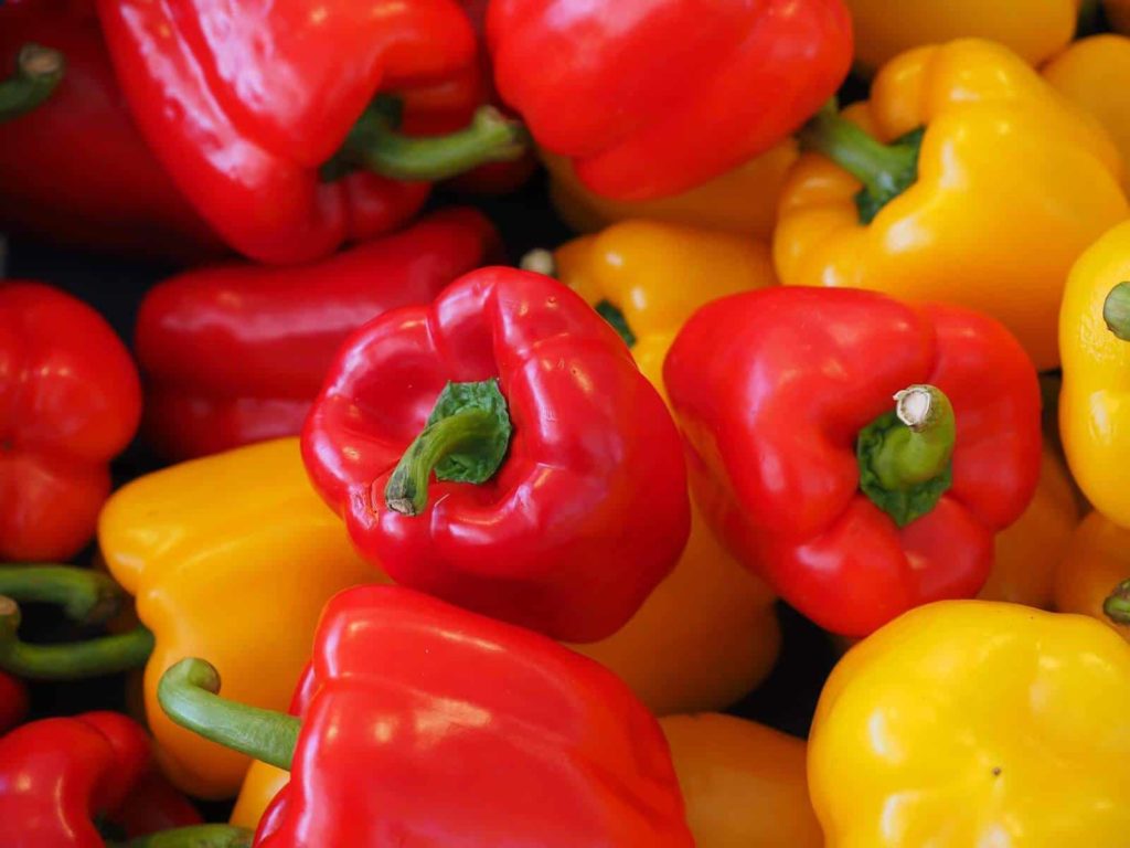 close up of red and yellow bell peppers