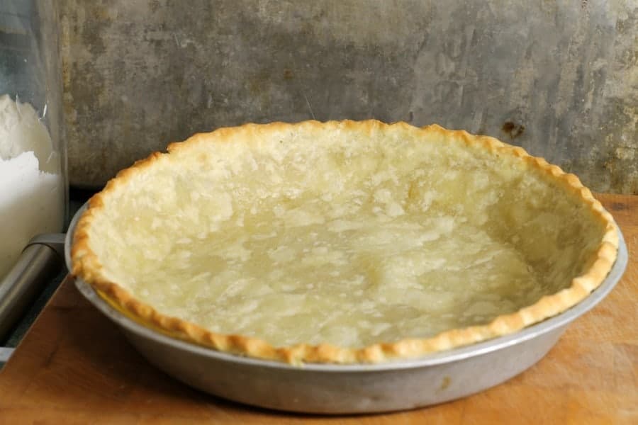 a blind baked pie crust on a wooden counter