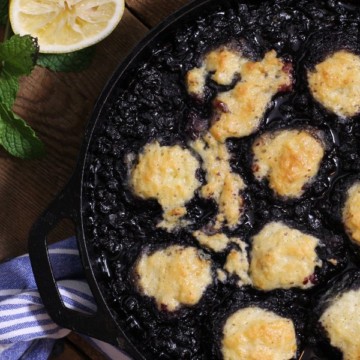a cast iron pan filled with freshly baked blueberry grunt.