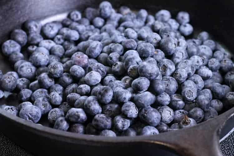 a cast iron pan filled with fresh blueberries