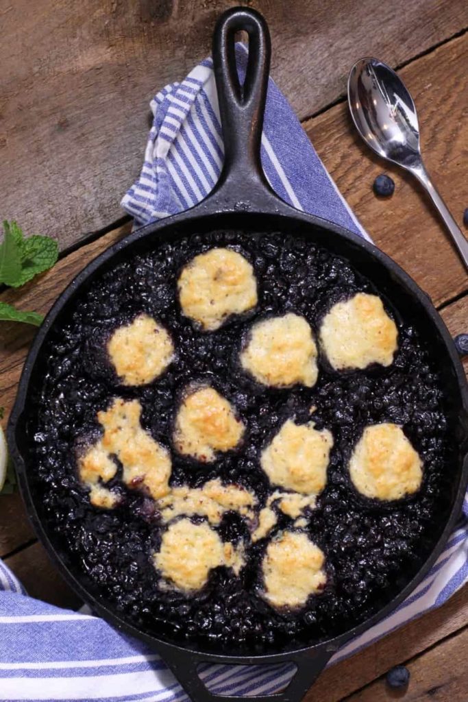 blueberry grunt baked in a cast iron dish with gold brown dumplings in it