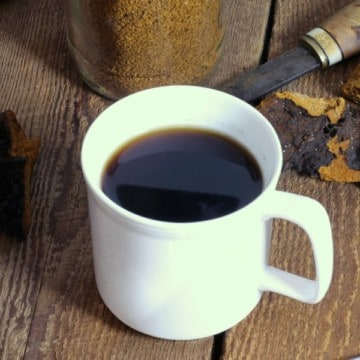 chaga mushroom tea in a white cup on a wooden tabletop