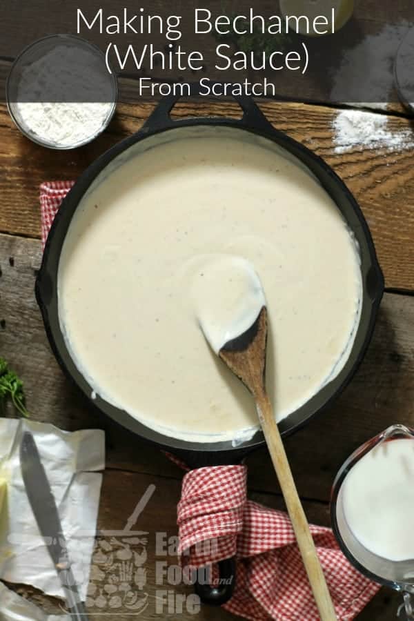 from scratch bechamel (white sauce) in a cast iron pan with a wooden spoon, surrounded by various ingredients