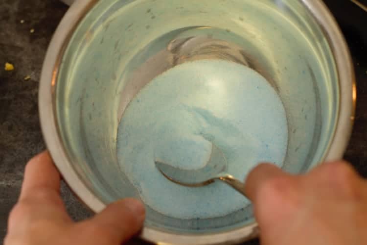 pastel blue colored sugar in a steel bowl