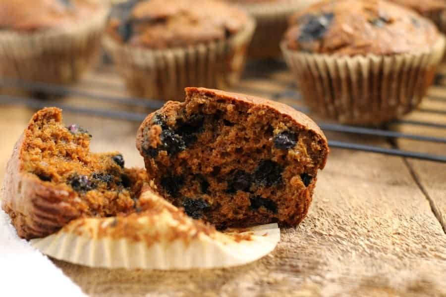 a blueberry bran muffin cut in half on a wooden board