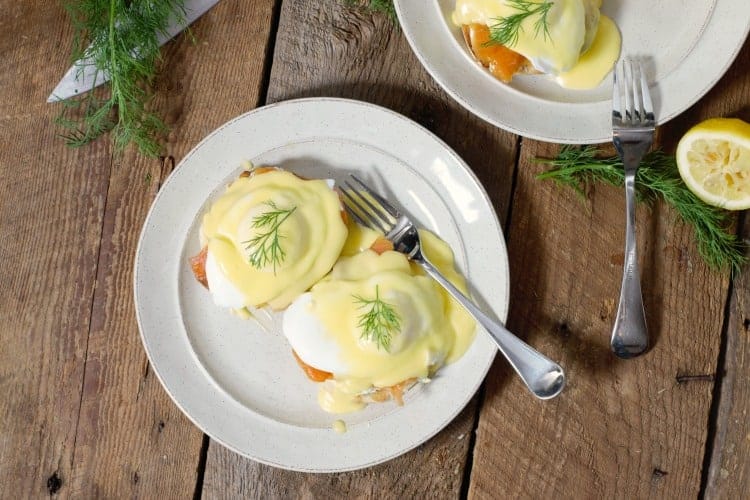 top down view of eggs benedict with smoked salmon on white plates