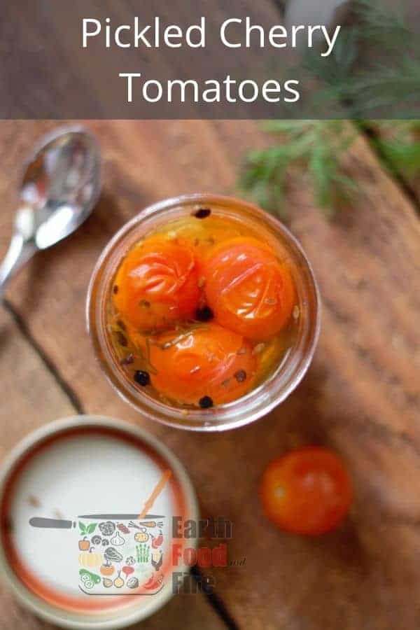 overhead shot of pickled cherry tomatoes in a mason jar with pinterest text overlaid