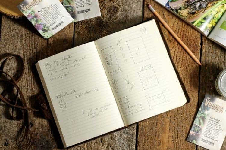 A leather bound notbook filled with notes on how to start a vegetable garden from scratch
