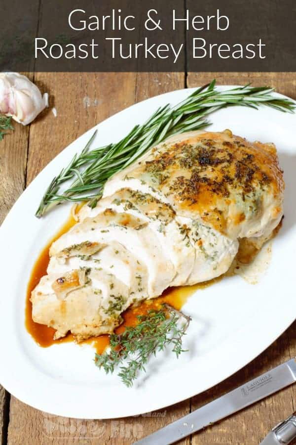 garlic and herb roasted turkey breast on a white serving platter