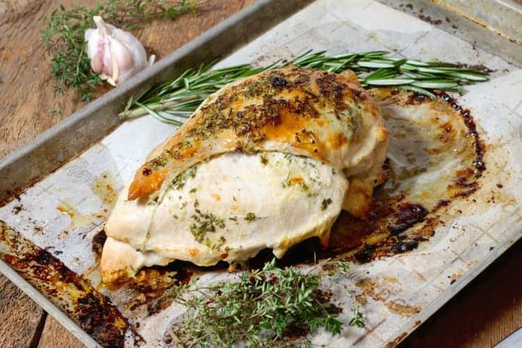 garlic and herb roasted turkey breast with a crisp golden skin on a sheet pan