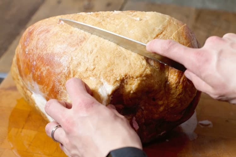 the fat on a ham butt being scored with a knife
