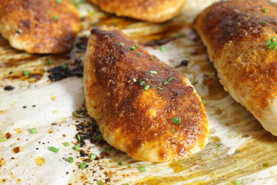 heavily seasoned oven baked chicken breasts on a sheet pan