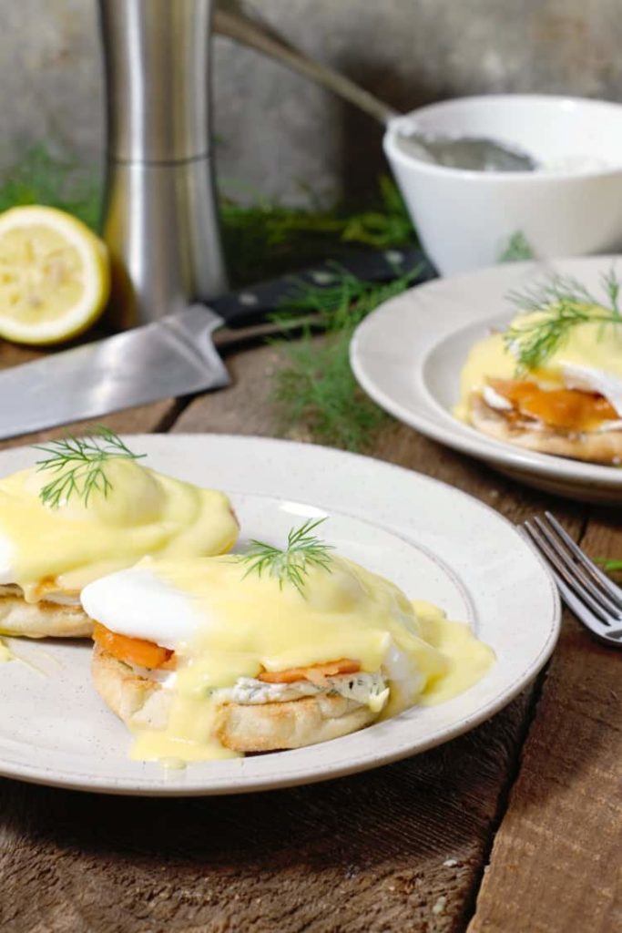 amoked salmon (eggs royale) served on white plates in a rustic table setting