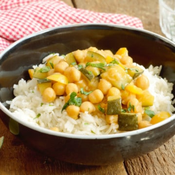 spiced chickpea curry served on basmati rice in a black bowl