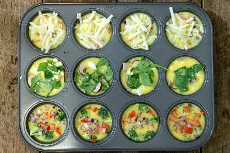 un cooked breakfast egg muffins assembled in a 12 cup muffin tin