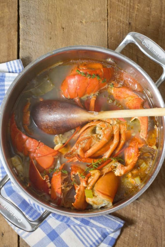vertical image of lobster stock in a large pot after cooking